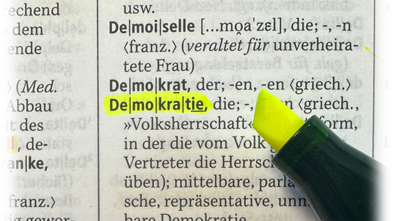 Das Foto zeigt einen Auszug aus einem Wörterbuch, in dem Demokratie unterstrichen ist.