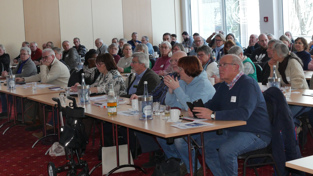 An Tischen sitzende Teilnehmende der Vereinekonferenz