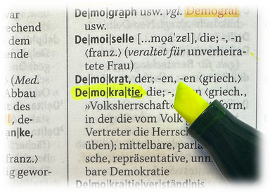 Das Foto zeigt einen Auszug aus einem Wörterbuch, in dem Demokratie unterstrichen ist.