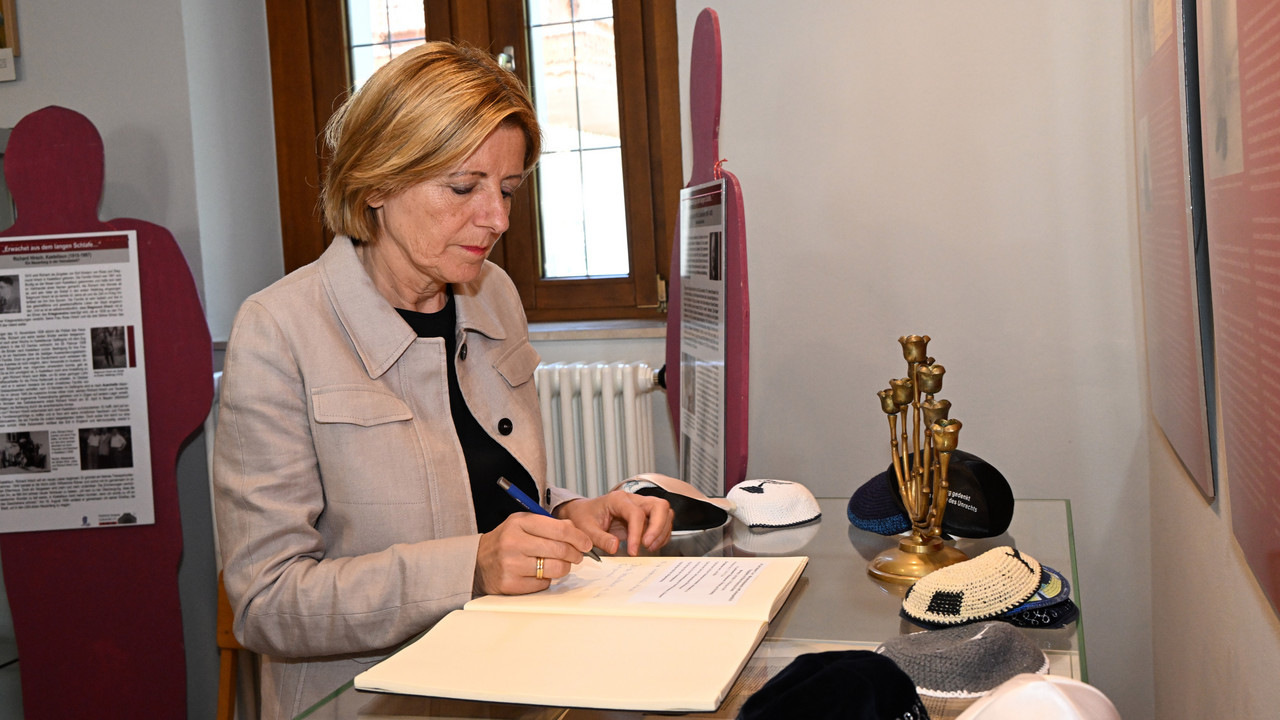 Ministerpräsidentin Malu Dreyer trägt sich in das Gästebuch der Synagoge in Laufersweiler ein. 
