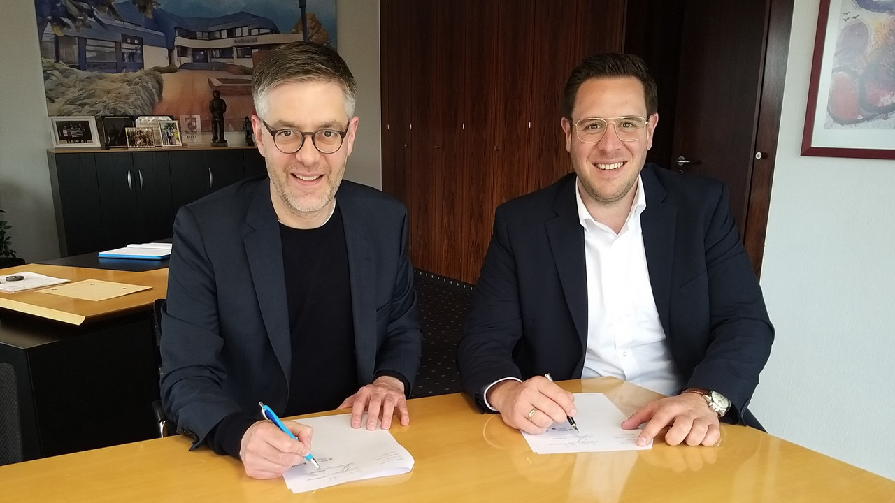 Staatssekretär Fabian Kirsch und Marcus Konrad, Bürgermeister der Verbandsgemeinde Speicher, bei der Unterzeichnung der Kooperationsvereinbarung für die Ehrenamtskarte. 